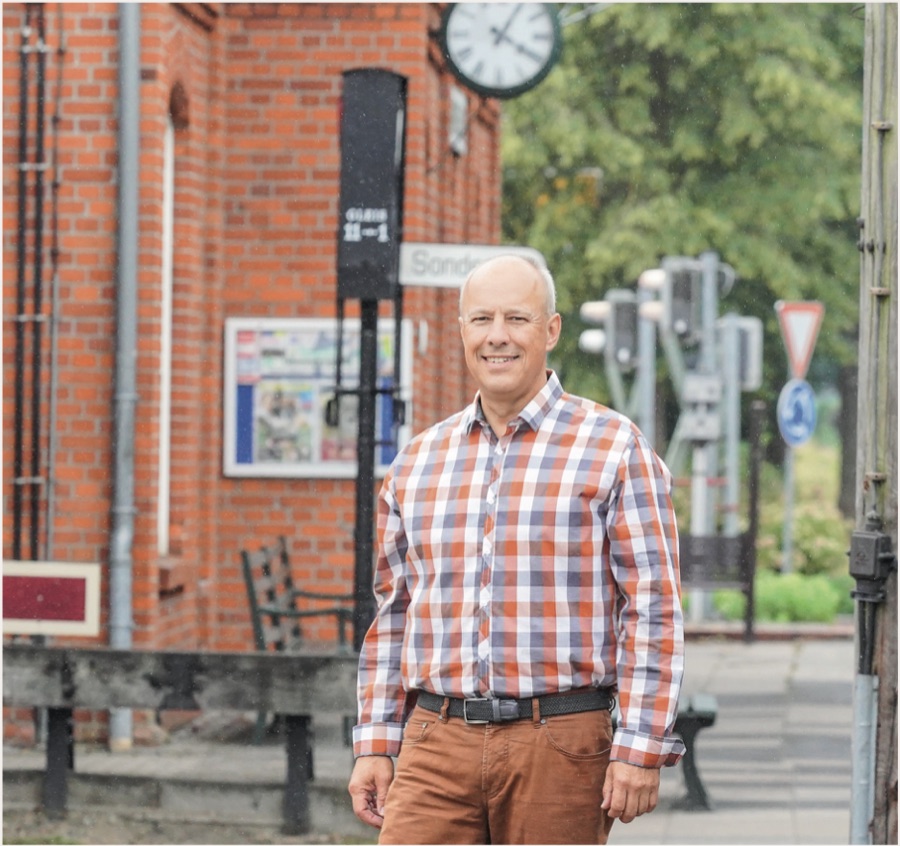 Dietmar Fischer vor einem Backsteingebäude mit Bahnhofsuhr